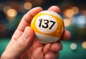 Рука крупним планом тримає більярдний шар із цифрою 137 на темному нейтральному фоні, символ загадкової фізичної константи.