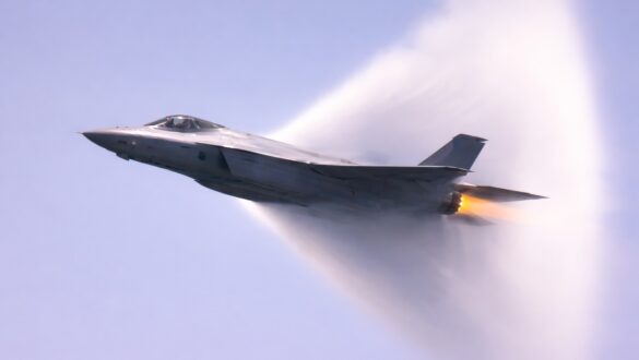 Винищувач F-35 у горизонтальному польоті долає звуковий бар’єр, утворюючи навколо себе конденсаційну ударну хвилю на тлі драматичного неба.