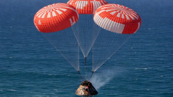Космічна капсула Orion спускається на парашутах над океаном після повернення з місії до Місяця.